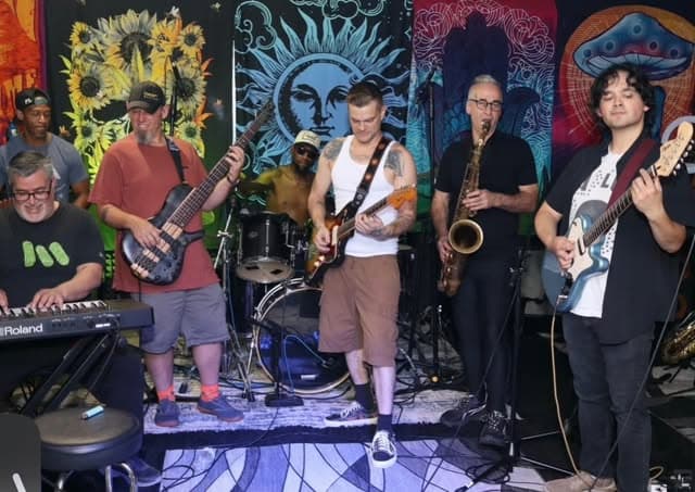 Gumbo full band playing in the studio in front of psychedelic tapestries